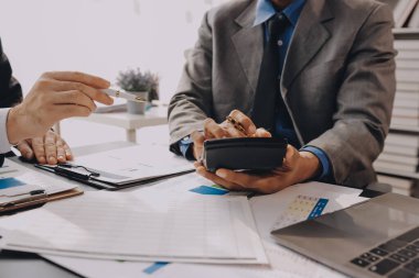 Muhasebe şirketi kazançlı nakit akışı için finansman ve vergilendirme planlaması, ofiste çalışan denetçi ve muhasebeci ekibi, mali verileri ve muhasebe kayıtlarını hesap makinesiyle analiz eder.