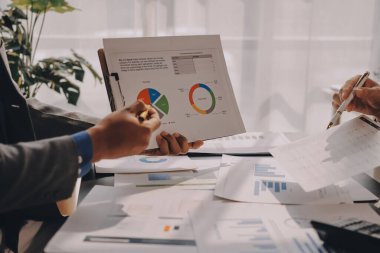 Muhasebe şirketi kazançlı nakit akışı için finansman ve vergilendirme planlaması, ofiste çalışan denetçi ve muhasebeci ekibi, mali verileri ve muhasebe kayıtlarını hesap makinesiyle analiz eder.