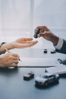 Araba satıcısı, satın alma sözleşmesini yasal olarak imzalayan müşterilere anahtar verdi, araba satışlarının başarıyla tamamlanması, satın alma sözleşmesi ve anahtar teslimatı..