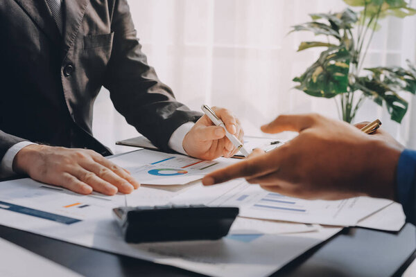 Бухгалтерская компания обеспечивает финансовое и налоговое планирование прибыльных денежных потоков, аудиторская и бухгалтерская команда, работающая в офисе, анализирует финансовые данные и бухгалтерскую отчетность с помощью калькулятора.