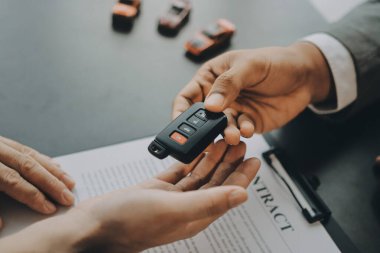 Araba satıcısı, satın alma sözleşmesini yasal olarak imzalayan müşterilere anahtar verdi, araba satışlarının başarıyla tamamlanması, satın alma sözleşmesi ve anahtar teslimatı..