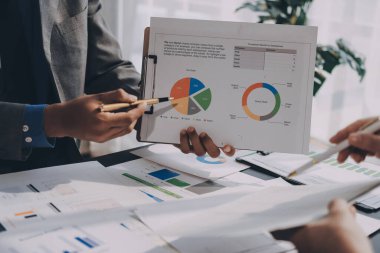 Muhasebe şirketi kazançlı nakit akışı için finansman ve vergilendirme planlaması, ofiste çalışan denetçi ve muhasebeci ekibi, mali verileri ve muhasebe kayıtlarını hesap makinesiyle analiz eder.