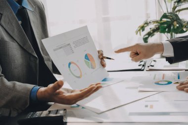 Muhasebe şirketi kazançlı nakit akışı için finansman ve vergilendirme planlaması, ofiste çalışan denetçi ve muhasebeci ekibi, mali verileri ve muhasebe kayıtlarını hesap makinesiyle analiz eder.