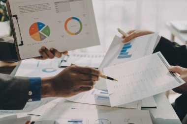 Muhasebe şirketi kazançlı nakit akışı için finansman ve vergilendirme planlaması, ofiste çalışan denetçi ve muhasebeci ekibi, mali verileri ve muhasebe kayıtlarını hesap makinesiyle analiz eder.