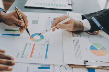 Muhasebe şirketi kazançlı nakit akışı için finansman ve vergilendirme planlaması, ofiste çalışan denetçi ve muhasebeci ekibi, mali verileri ve muhasebe kayıtlarını hesap makinesiyle analiz eder.