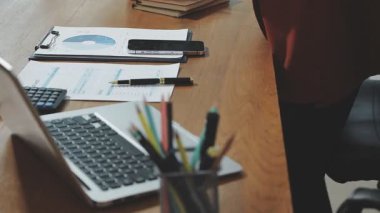 Genç işadamı ofiste dizüstü bilgisayar kullanıyor.