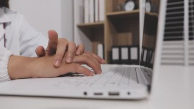 Evde çalışan genç bir kadın, dizüstü bilgisayar kullanıyor, klavyede daktilo kullanıyor.
