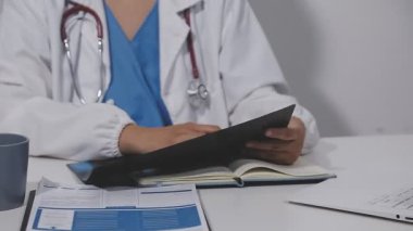 Beyaz üniformalı genç bir doktor ve klinikte çalışan bir doktor. Sağlık ve Tıp Konsepti