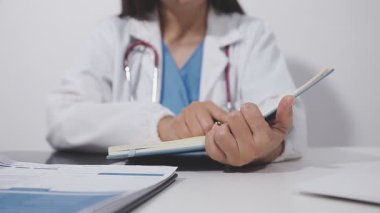 Kapalı - bir doktorun hastasının not defterine oturup notlar yazması