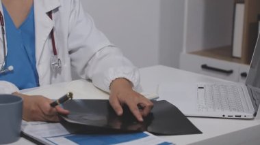 Ofiste dizüstü bilgisayar kullanan bir doktor..