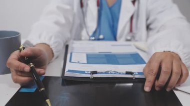 Tıp doktoru ofiste dizüstü bilgisayarla çalışıyor.