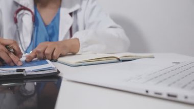 Doktor işyerinde reçete yazıyor.