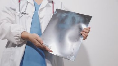 Röntgen cihazını tutan beyaz üniformalı doktor.