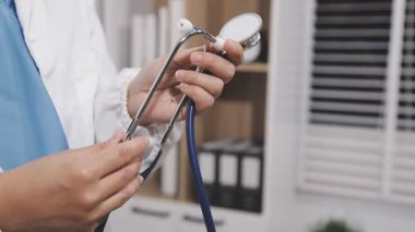 Ofisteki masada steteskopu tutan doktor.