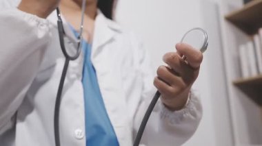 Kadın doktor hastanede steteskop kullanıyor. Tıp doktoruna yakın çekim..