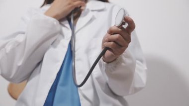 Doktor beyaz üniforma ve açık gri arka planda steteskop verdi..