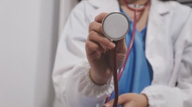 Stetoskop tutan kadın doktorlara yakın çekim.