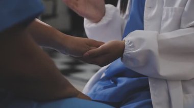 yakın çekim - doktorun elleri hastanın elini tutuyor.