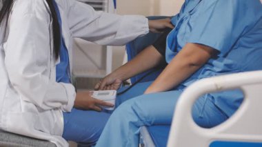 Tıbbi üniformalı genç bir kadın odada bir şırınga ve iğne tutuyor.