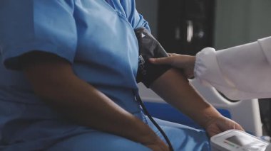 Steteskoplu beyaz üniformalı bir doktor.