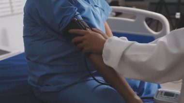 Hastane koğuşundaki bir hastayı muayene eden kadın hemşire..