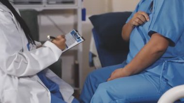 Doktor ve asistan hastanede hastayla konuşuyor..