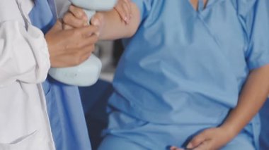 Steteskoplu doktor elini tutuyor.