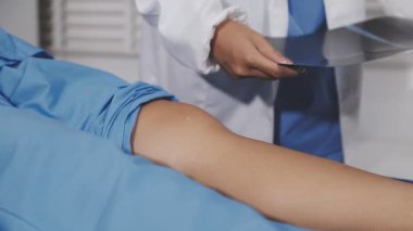 Doktor hastaların dizlerini kontrol ediyor..