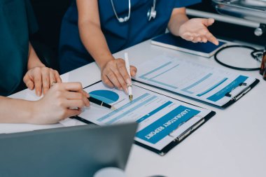 Medical team meeting analyzing blood test results in hospital laboratory. Doctors and scientists in lab coats are having a discussion about blood test result, holding test tubes and taking notes.