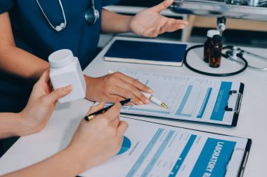 Medical team meeting analyzing blood test results in hospital laboratory. Doctors and scientists in lab coats are having a discussion about blood test result, holding test tubes and taking notes.