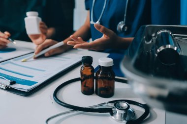 Medical team meeting analyzing blood test results in hospital laboratory. Doctors and scientists in lab coats are having a discussion about blood test result, holding test tubes and taking notes.