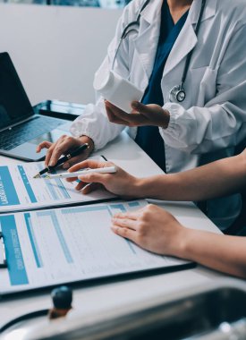 Medical team meeting analyzing blood test results in hospital laboratory. Doctors and scientists in lab coats are having a discussion about blood test result, holding test tubes and taking notes.