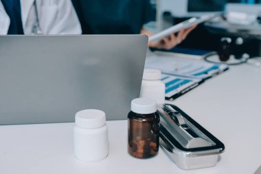 Medical team meeting analyzing blood test results in hospital laboratory. Doctors and scientists in lab coats are having a discussion about blood test result, holding test tubes and taking notes.