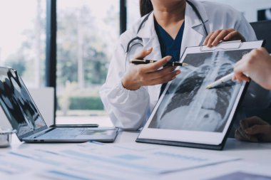 Medical team meeting analyzing blood test results in hospital laboratory. Doctors and scientists in lab coats are having a discussion about blood test result, holding test tubes and taking notes.