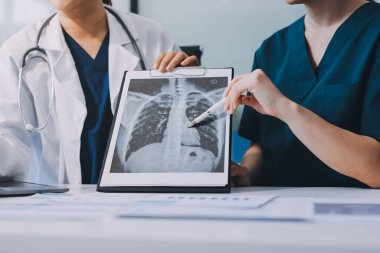 Medical team meeting analyzing blood test results in hospital laboratory. Doctors and scientists in lab coats are having a discussion about blood test result, holding test tubes and taking notes.