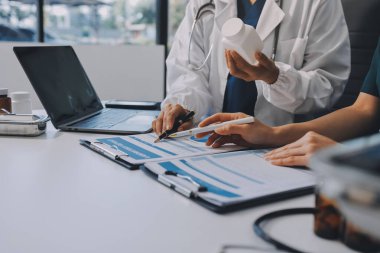 Medical team meeting analyzing blood test results in hospital laboratory. Doctors and scientists in lab coats are having a discussion about blood test result, holding test tubes and taking notes.