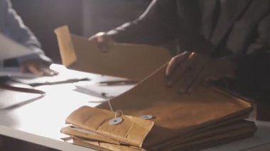 man working in the office. man in a white suit. the man is working on a table.