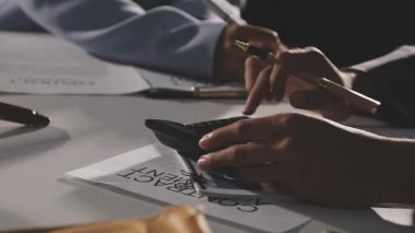 man in a suit writing a pen in a diary