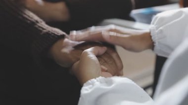 close up of hands of a young couple holding hands together