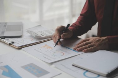 Hesap makinesi ve dizüstü bilgisayarı kullanarak ahşap masa, vergi, muhasebe, istatistik ve analitik araştırma konseptine matematik finansmanı sağlayan İş kadını kapat