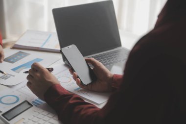 Hesap makinesi ve dizüstü bilgisayarı kullanarak ahşap masa, vergi, muhasebe, istatistik ve analitik araştırma konseptine matematik finansmanı sağlayan İş kadını kapat