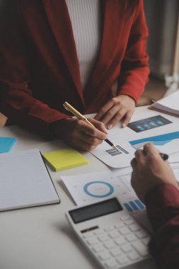 Hesap makinesi ve dizüstü bilgisayarı kullanarak ahşap masa, vergi, muhasebe, istatistik ve analitik araştırma konseptine matematik finansmanı sağlayan İş kadını kapat