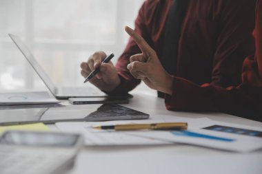 Hesap makinesi ve dizüstü bilgisayarı kullanarak ahşap masa, vergi, muhasebe, istatistik ve analitik araştırma konseptine matematik finansmanı sağlayan İş kadını kapat