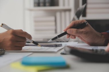 Hesap makinesi ve dizüstü bilgisayarı kullanarak ahşap masa, vergi, muhasebe, istatistik ve analitik araştırma konseptine matematik finansmanı sağlayan İş kadını kapat