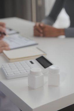 Asyalı doktor kadın, teşhis koymak ve evdeki ya da özel hastanedeki sağlığı kontrol etmek için hasta kadını ziyaret etti. Kadın hasta, sağlık sorununu ve belirtileri doktorlara açıklar.
