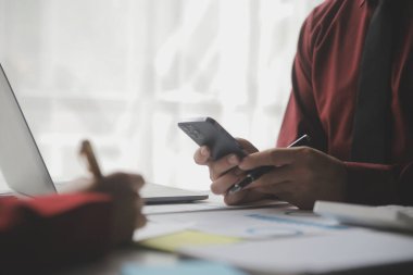 Hesap makinesi ve dizüstü bilgisayarı kullanarak ahşap masa, vergi, muhasebe, istatistik ve analitik araştırma konseptine matematik finansmanı sağlayan İş kadını kapat