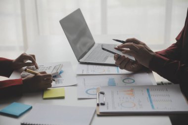 Hesap makinesi ve dizüstü bilgisayarı kullanarak ahşap masa, vergi, muhasebe, istatistik ve analitik araştırma konseptine matematik finansmanı sağlayan İş kadını kapat