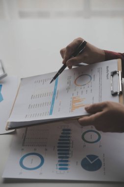 Hesap makinesi ve dizüstü bilgisayarı kullanarak ahşap masa, vergi, muhasebe, istatistik ve analitik araştırma konseptine matematik finansmanı sağlayan İş kadını kapat