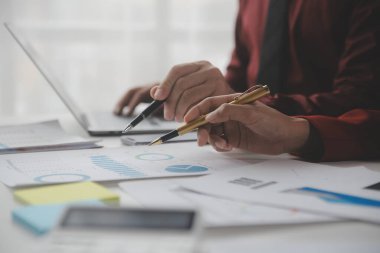 Hesap makinesi ve dizüstü bilgisayarı kullanarak ahşap masa, vergi, muhasebe, istatistik ve analitik araştırma konseptine matematik finansmanı sağlayan İş kadını kapat