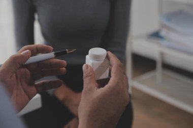 Asyalı doktor kadın, teşhis koymak ve evdeki ya da özel hastanedeki sağlığı kontrol etmek için hasta kadını ziyaret etti. Kadın hasta, sağlık sorununu ve belirtileri doktorlara açıklar.